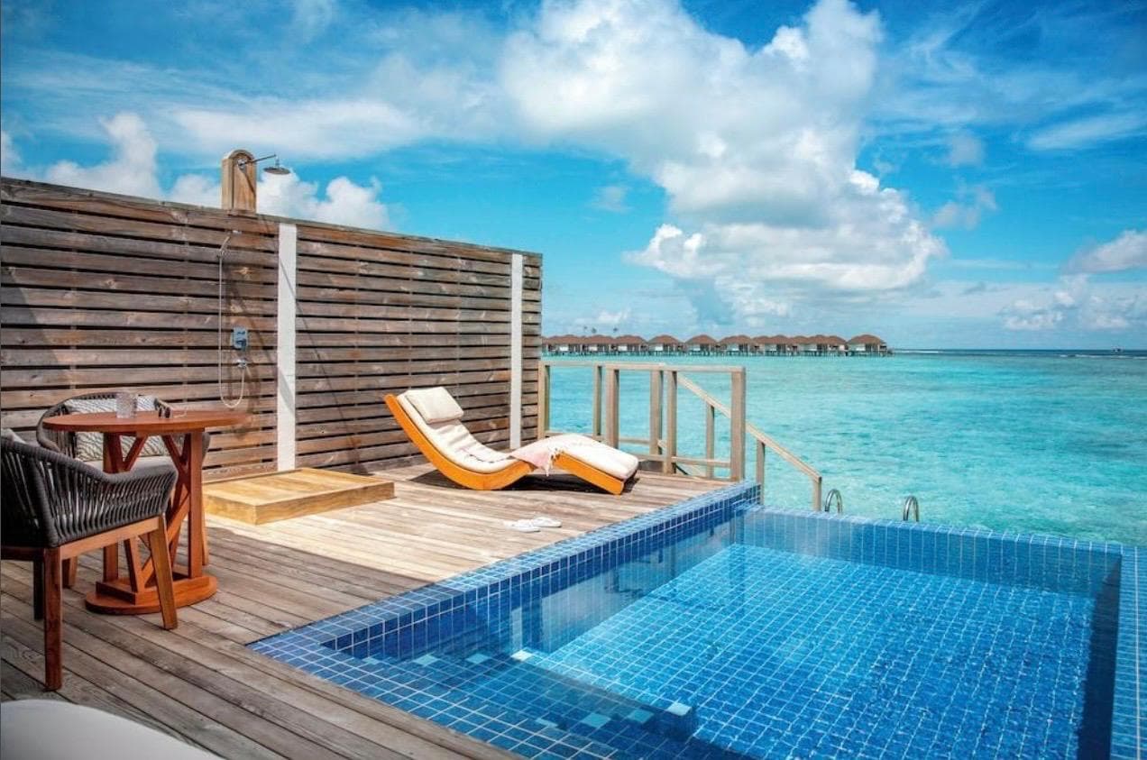 The villa's plunge pool and sun loungers on a teak deck facing open water