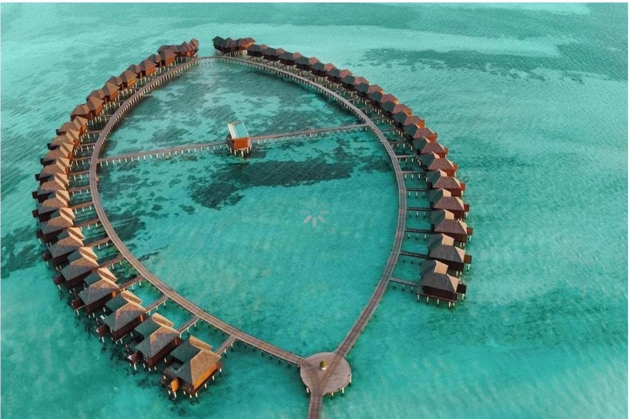 The resort's jetty curving out across the lagoon, villas along both sides