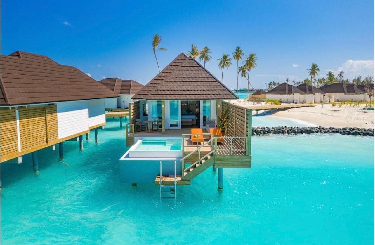 A five-star overwater villa with a private plunge pool above a turquoise Maldivian lagoon
