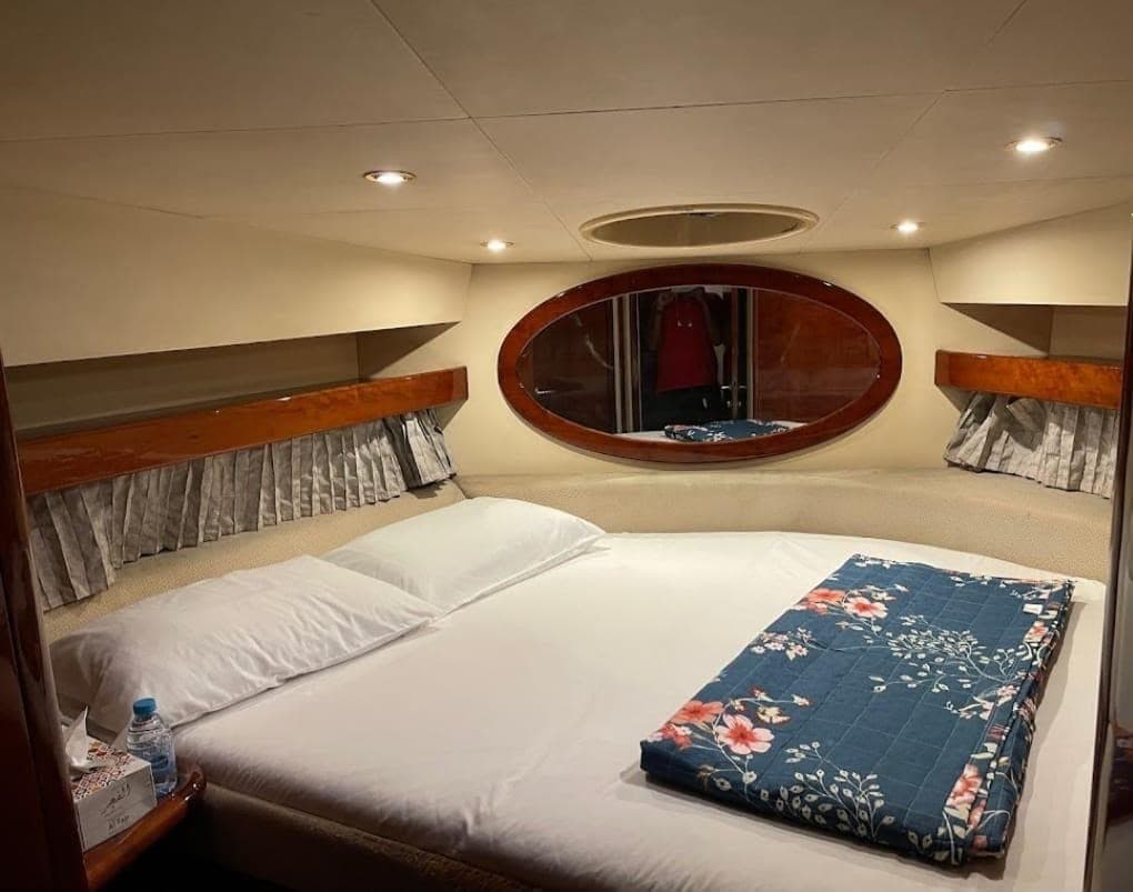 The cabin below deck, with a made-up double bed and reading lights