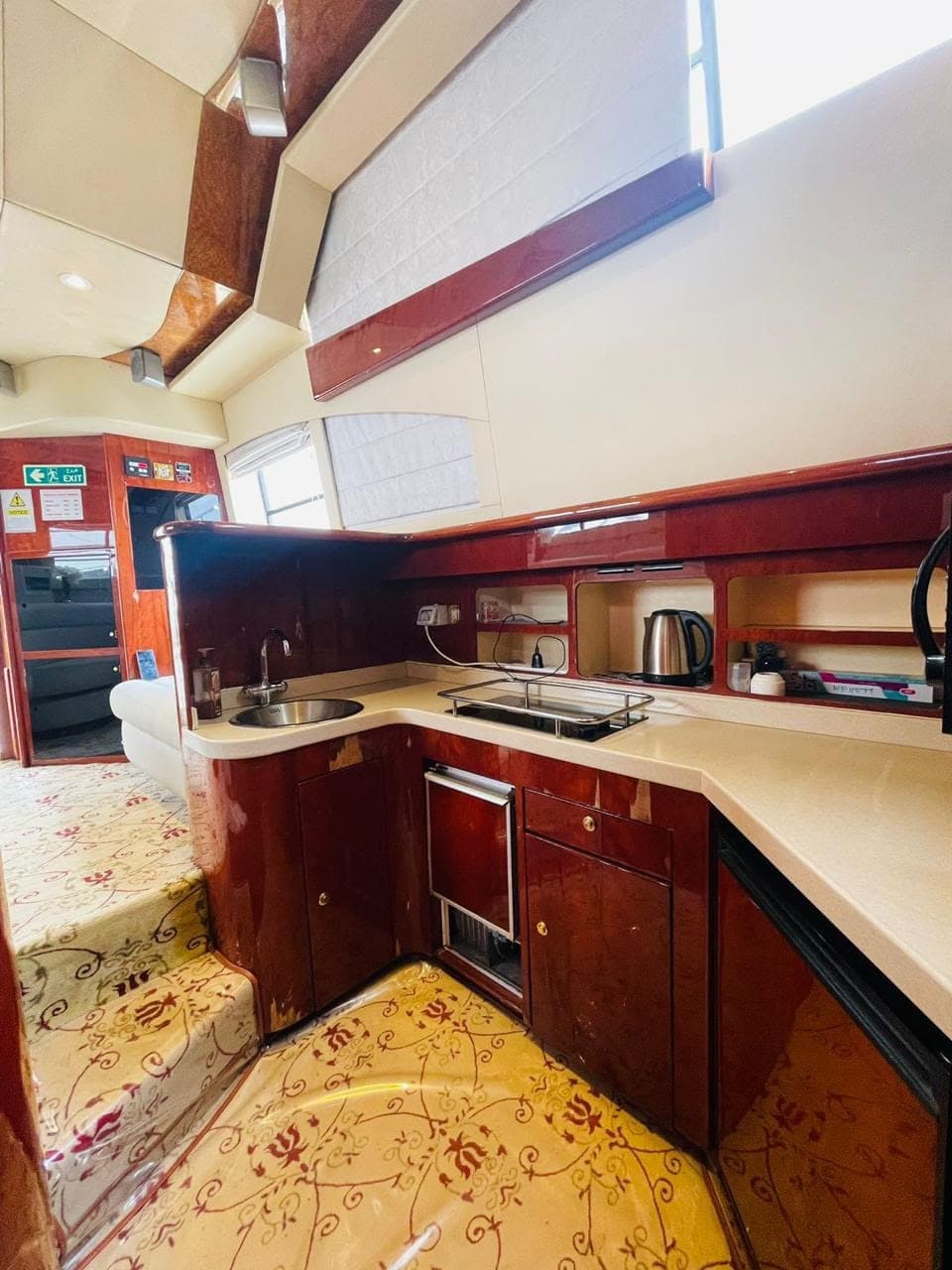 The galley on board, with a sink, hob, kettle and polished cabinets