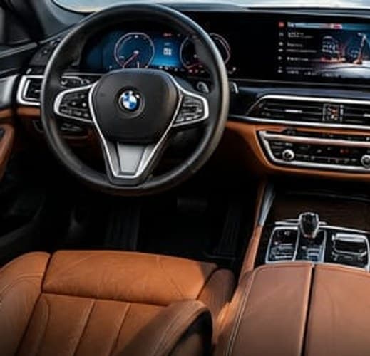 The BMW 7 Series driver's seat, wheel and centre screen above a tan leather cabin