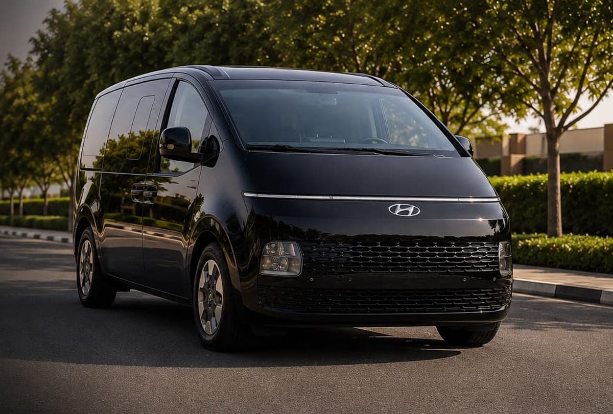 The black Hyundai Staria on a tree-lined Dubai road