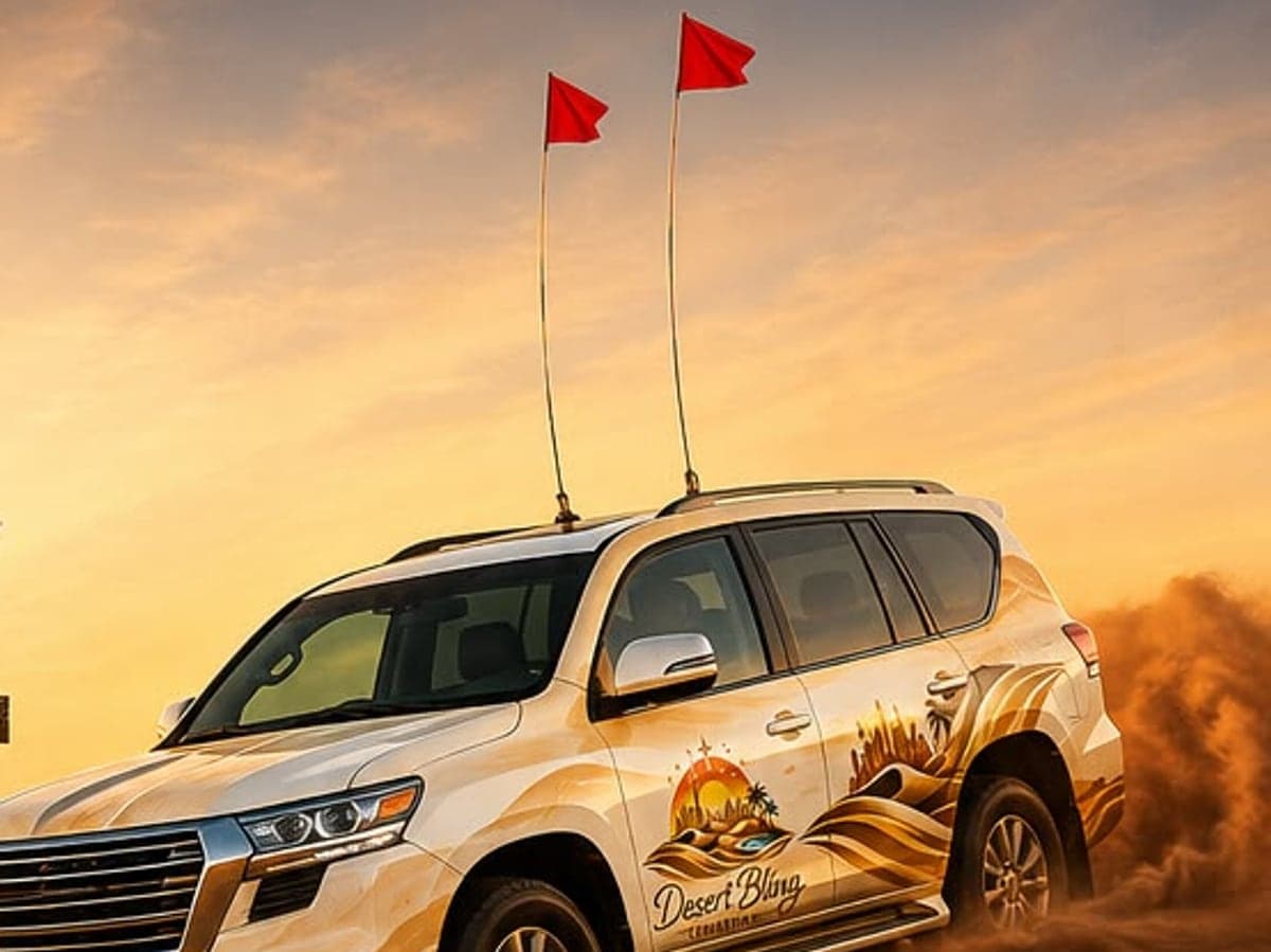 A Desert Bling Tourism 4x4 in the red dunes at sunset, dune flags up
